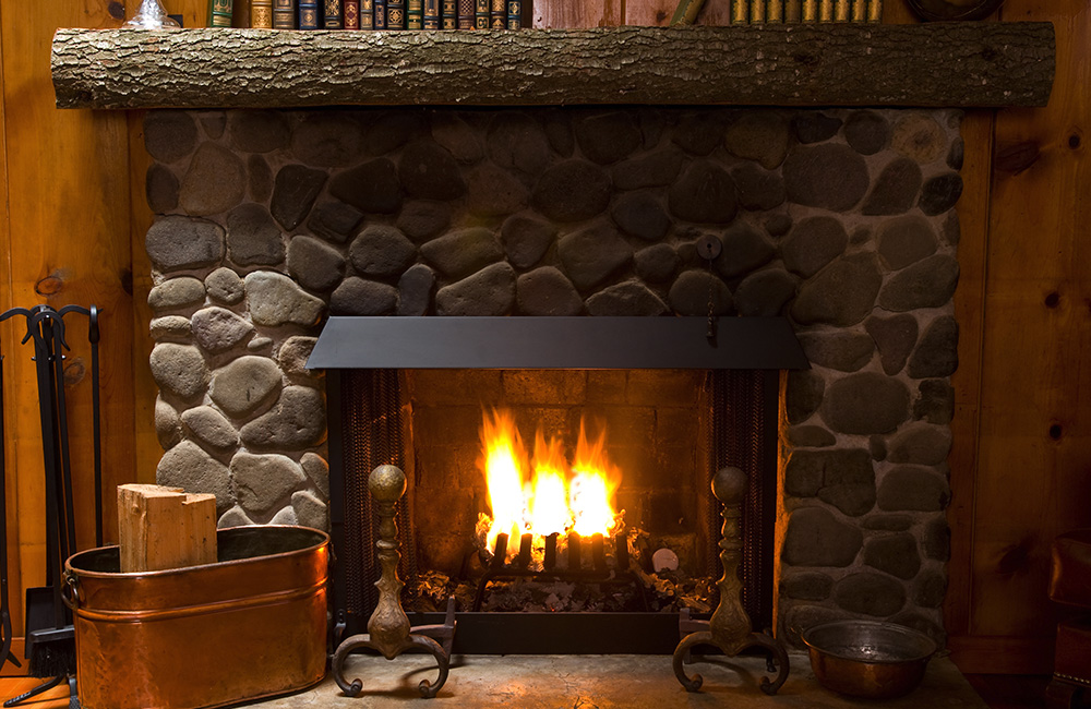 burning fire inside an indoor stone fireplace
