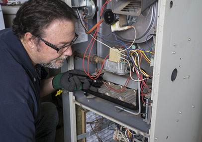 Reckingers Heating & Cooling HVAC employee auditing a heating system